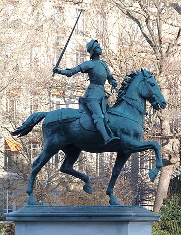 Equestrian statue of Joan of Arc in Place Saint-Augustin, Paris. Her armored figure holding a flag symbolizes her courage and conviction.