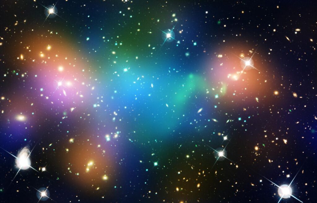 Composite image showing the distribution of dark matter, galaxies, and hot gas in the core of the merging galaxy cluster Abell 520. Orange represents starlight from galaxies, green shows hot gas, and blue indicates the distribution of dark matter. The mixture of blue and green in the center, where few galaxies are seen, indicates the presence of a dark matter clump, challenging existing theories about dark matter's nature.